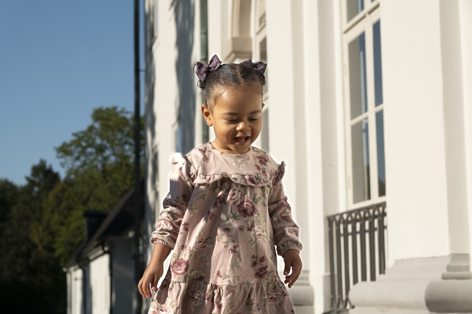 Young child walking outside in a floral dress